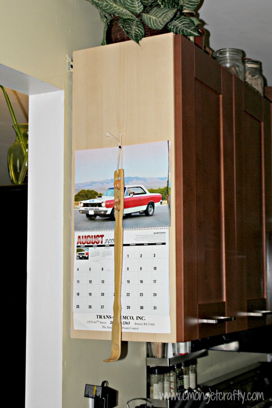 cmongetcraftyclipboardmakeovermoms - C'mon Get Crafty side of kitchen cabinet with a plain cars calendar hanging on it