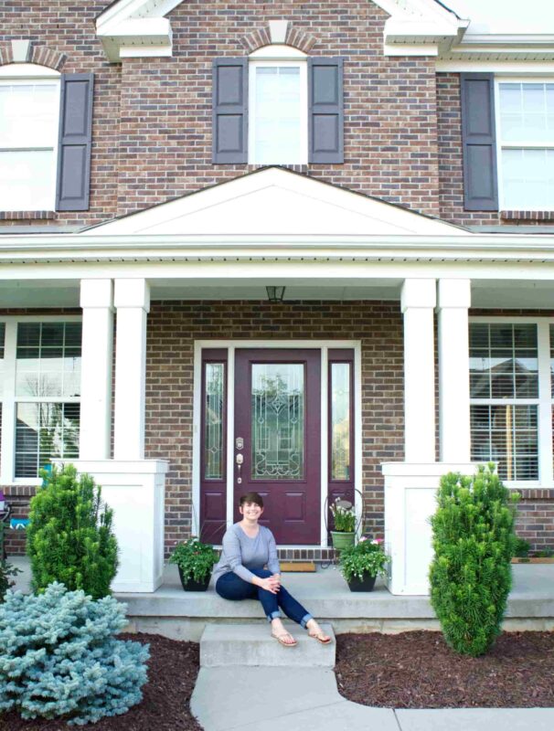 New Front Door woman sitting on front step in front of new purple door to her home