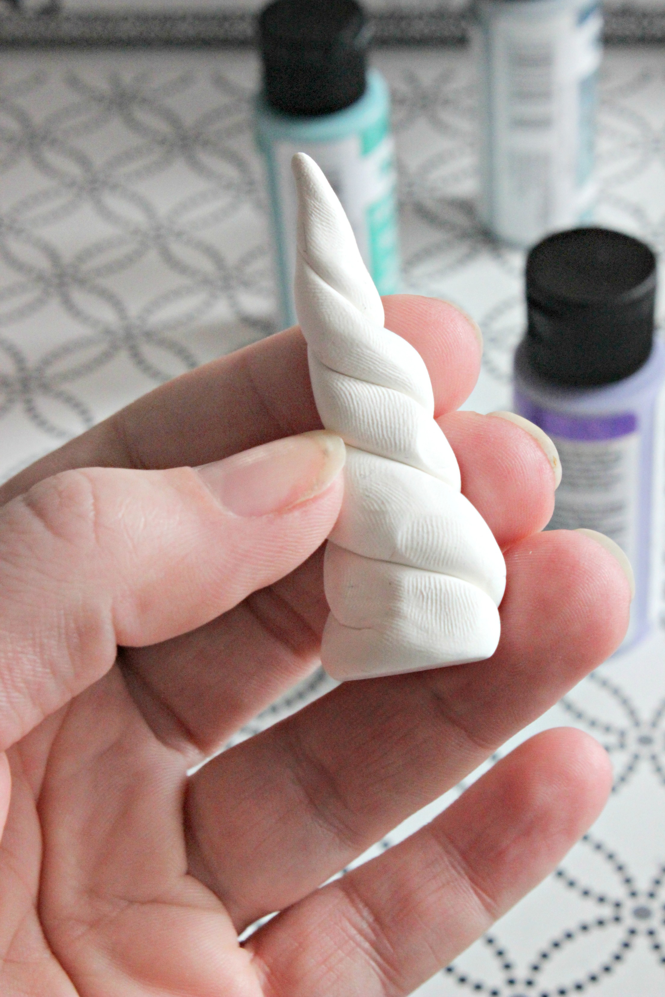 Shaping a unicorn horn out of clay - C'mon Get Crafty A little glitter and a little creativity creates a fabulous, sparkly unicorn ornament! See how you can make one as well! #christmas #ornamentdiy #unicorndiy