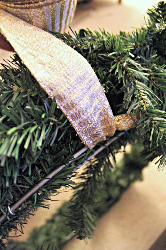 Wrapping ribbon around diy wreath-opt - C'mon Get Crafty It isn't terribly hard or expensive to decorate a hand me down Christmas wreath and spruce up your front door!