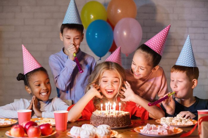 Kids birthday party blowing out the candles around the cake