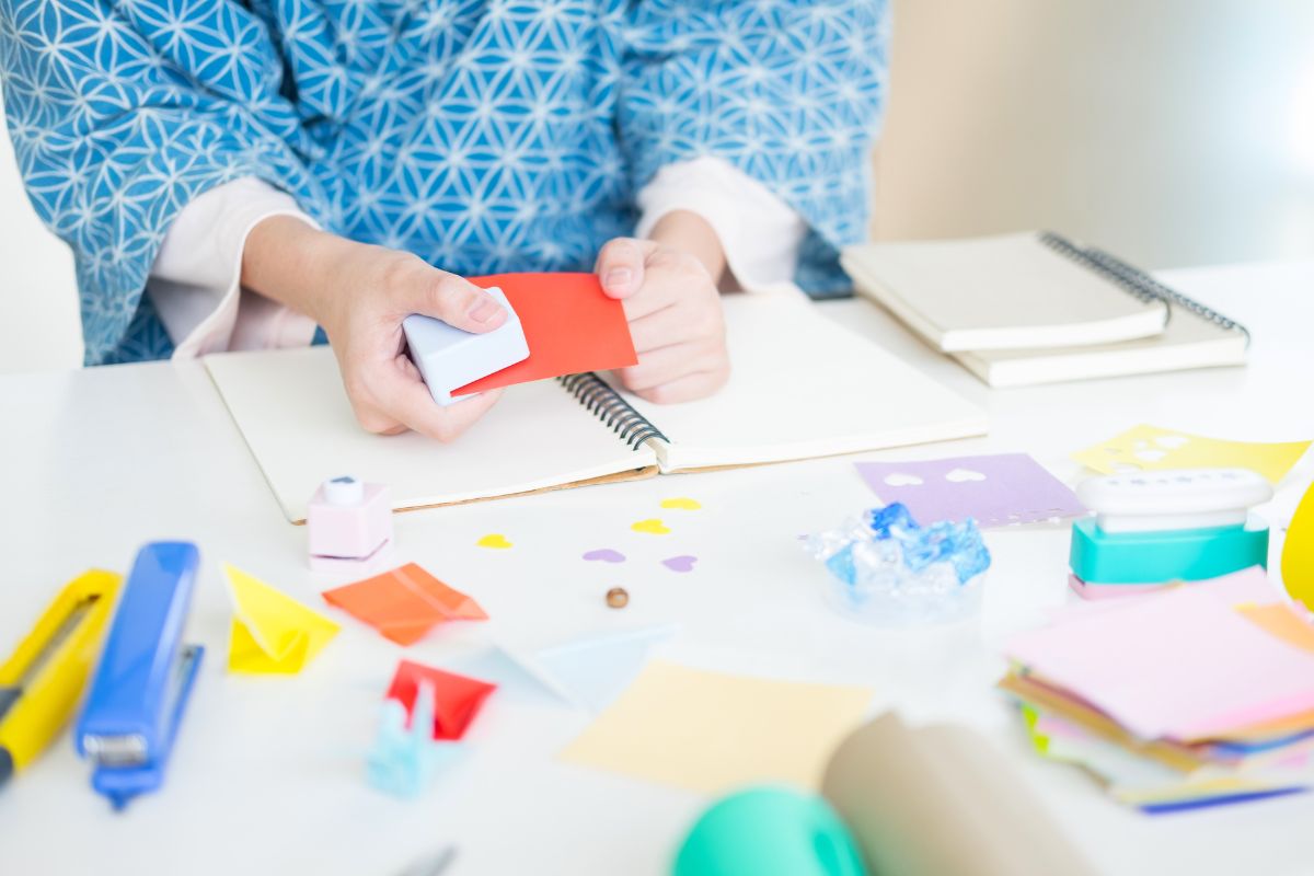 kid hands using paper cutter to scrapbook