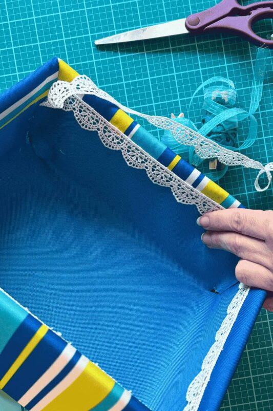Outdoor Fabric Box Liner Ribbon - C'mon Get Crafty White lacy ribbon lining being adhered to inside of fabric covered box.