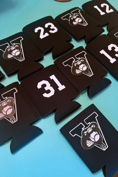 Jack Viper Koozies - C'mon Get Crafty A collection of black can coolers with white numbers or a white logo of a snake biting a baseball. The numbers range from 12 to 31.